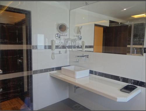 a white bathroom with a sink and a mirror at The Four Seasons Recreation in Jālgaon