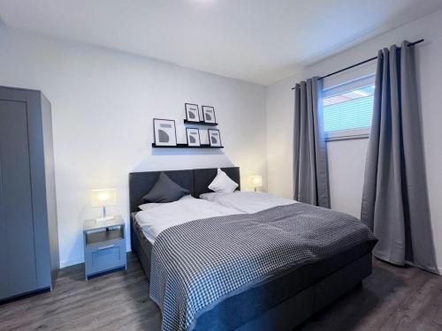a bedroom with a bed with two pictures on the wall at Emsland Hus WG2 in Niederlangen