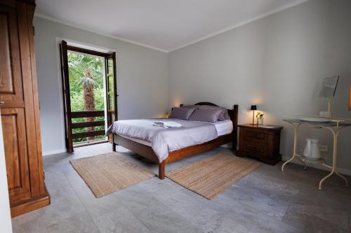 a bedroom with a bed and a table and a window at Campanile Nero in Prata Camportaccio
