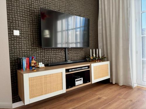 a flat screen tv sitting on top of a entertainment center at Ferienwohnung "Zur Amsel" in Burkhardtsdorf