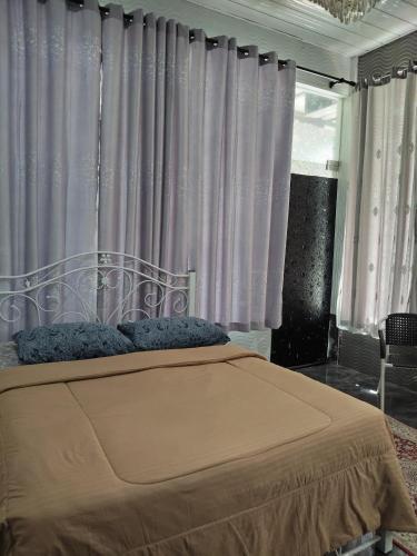a bedroom with a bed with purple curtains at Makwan Homestay C in Kubang Semang