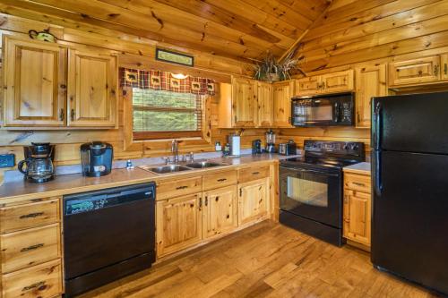 a kitchen with wooden cabinets and a black refrigerator at Simply Heaven in the Smokies By Avada Properties in Wear Valley