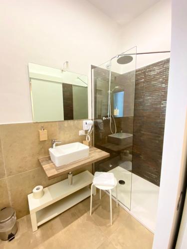 a bathroom with a sink and a glass shower at Il Re degli Scalzi in Matera