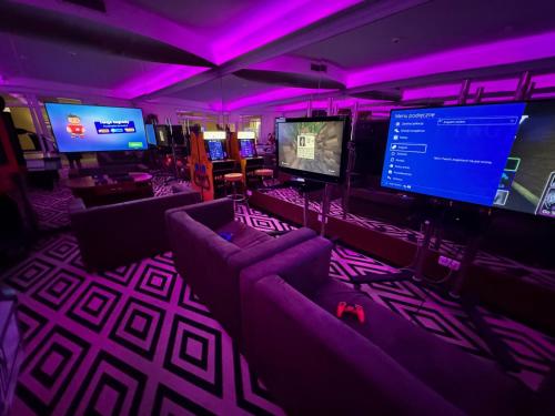 a room with couches and televisions and purple lights at Hotel SPA Faltom Gdynia Rumia in Rumia