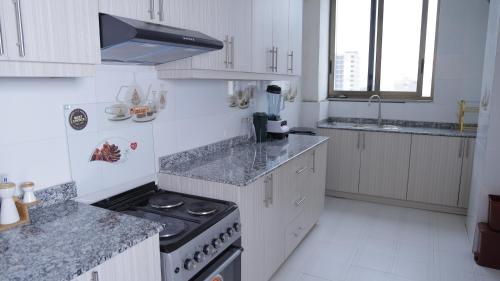 a kitchen with white cabinets and a stove top oven at My Dream Apartment in Addis Ababa