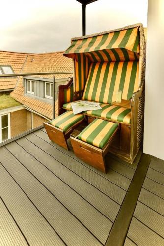 ein Balkon mit einer Bank auf einem Dach in der Unterkunft Juister Zauber  Ferienwohnung Sonnendüne in Juist