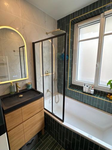 Un baño con ducha, lavabo y bañera. en Chambre au Jardin, en París