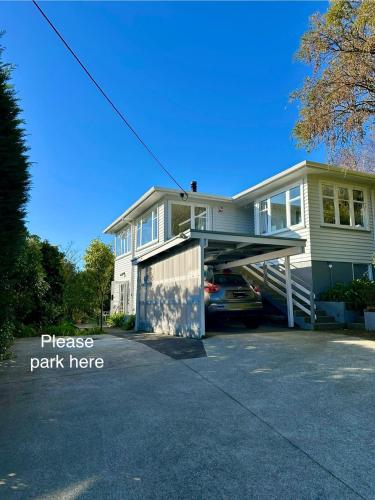 a house with a car parked in a driveway at Lemon Tree Apartment Tawa in Wellington