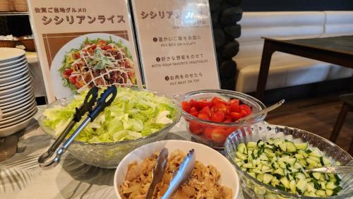 a table topped with bowls of salad and vegetables at APA Hotel Saga Ekimae Chuo in Saga