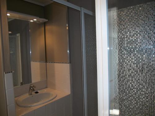 a bathroom with a sink and a glass shower at Maison avec Sauna Saint-Valery-sur-Somme in Saint-Valery-sur-Somme