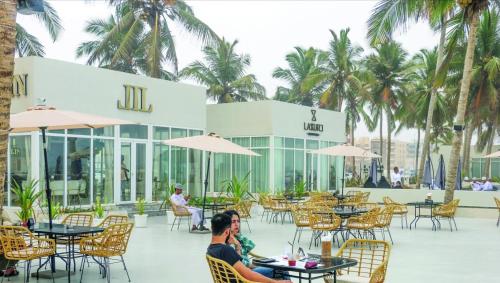 a group of people sitting at tables in a restaurant at Luxury sea view apartment in Dahariz, Salalah شقة بحرية فاخرة بمنطقة الدهاريز السياحية بصلالة ظفار in Salalah