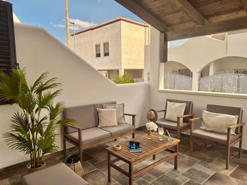 a patio with couches and a table on a balcony at Casa Paola vista mare - Starlink in Specchiolla 
