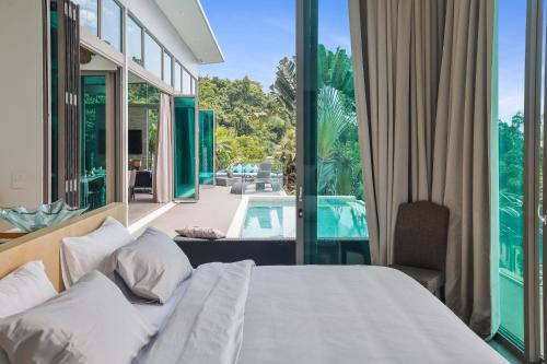 a bedroom with a bed and a view of a pool at Phuket Seaview Villa - Private Sauna - Steamroom - Infinity Swimmingpool in Ban Pa Khlok