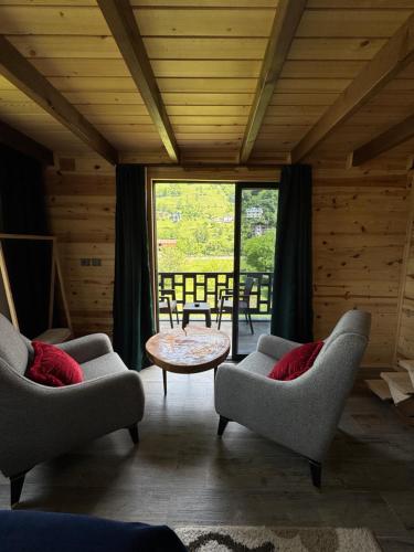 a living room with two chairs and a table at Pallas Otel in Ardeşen