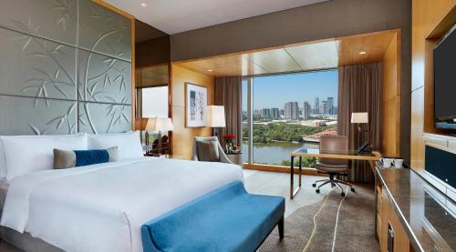 a bedroom with a bed and a desk and a window at The Azure Ningbo, Vignette Collection in Ningbo