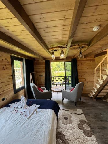 a bedroom with a bed and chairs in a cabin at Pallas Otel in Ardeşen