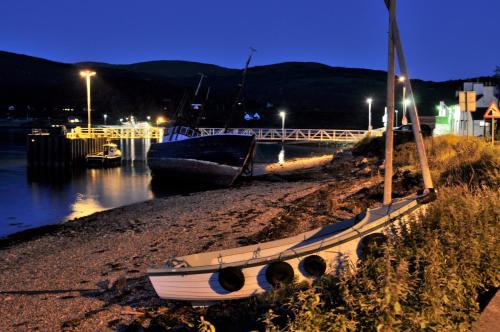 two boats sitting on the shore at night at Inn at Ardgour in Onich