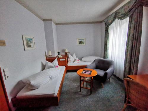 a hotel room with a bed and a couch and a table at Kaiserstühler-Hof in Breisach am Rhein