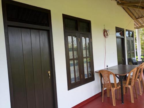 a dining room with a table and chairs and a door at Bird Nest Guest House in Lukasgoda
