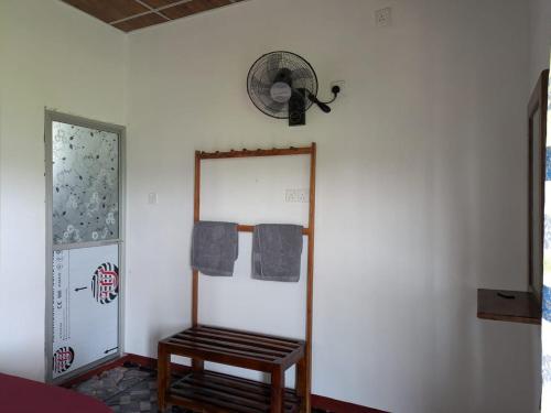 a room with a mirror and a chair and a fan at Bird Nest Guest House in Lukasgoda
