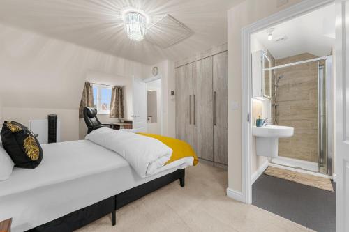 Un dormitorio blanco con una cama y un baño. en 4 Bedroom House In Manchester, en Mánchester