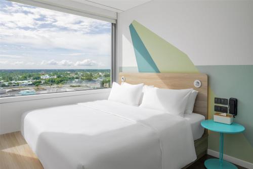 Vị ThanhにあるTru by Hilton Hau Giang City Centreの大きな白いベッドと大きな窓のある寝室