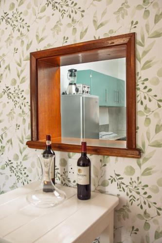 two bottles of wine sitting on a counter in front of a mirror at Die Veldskoen in Montagu