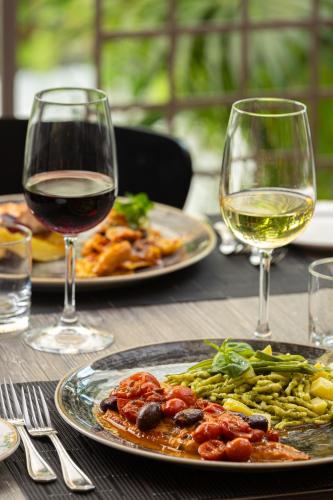 a table with two plates of food and two glasses of wine at Crowne Plaza Milan Linate by IHG in San Donato Milanese
