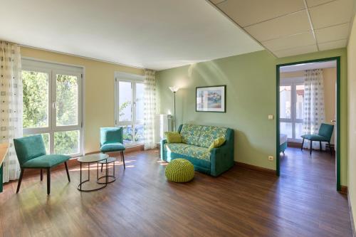a living room with a couch and two chairs at Apartments Aschheim in Aschheim