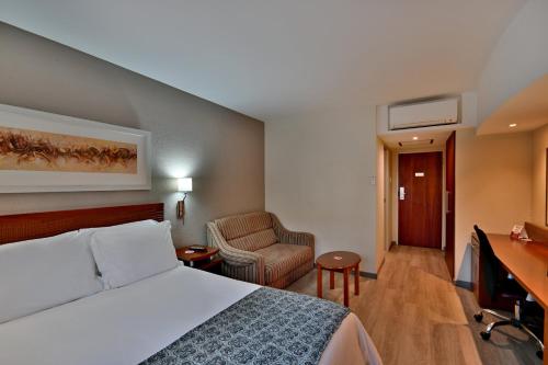 a hotel room with a bed and a desk at City Lodge Hotel Gqeberha in Port Elizabeth