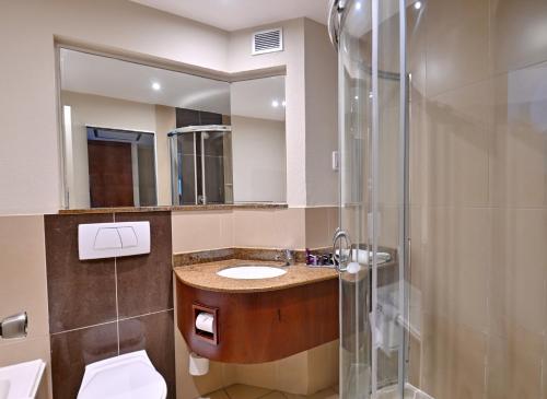 a bathroom with a sink and a shower at City Lodge Hotel Gqeberha in Port Elizabeth