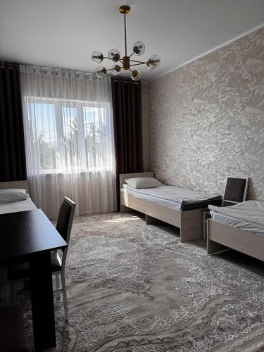 a bedroom with two beds and a window at Cholpon Guest House & Hostel in Toktogul