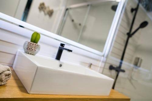 a bathroom with a white sink and a mirror at Atico En Faro in Roquetas de Mar