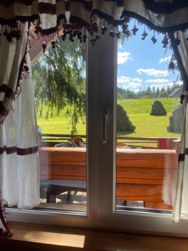 a window with a view of a green field at Садиба Урочище Луг in Vorokhta