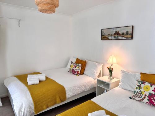 a room with two beds and a table with a lamp at Stylish Entire Apartment with Private Garden in Camden, Central London in London