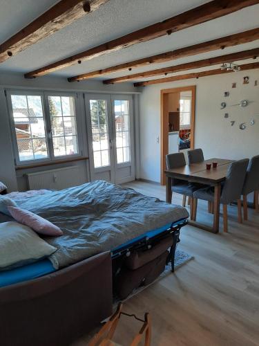 a bedroom with a bed and a table and chairs at Appartement confortable avec terrasse in Zweisimmen