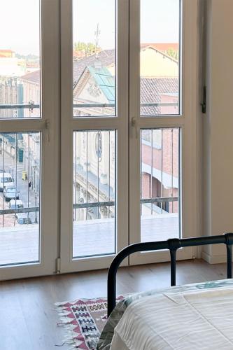 ein Schlafzimmer mit vier Fenstern, einem Bett und einer Aussicht in der Unterkunft Suite del Campione in Asti