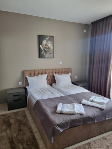 a bedroom with a bed with two towels on it at Apartament Rumqncev in Velingrad