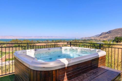 a jacuzzi tub on a balcony with a view at לה כינרה - ווילה מדהימה עם בריכה פרטית ונוף לכנרת במגדל in Migdal