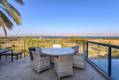 a patio with a table and chairs on a balcony at לה כינרה - ווילה מדהימה עם בריכה פרטית ונוף לכנרת במגדל in Migdal