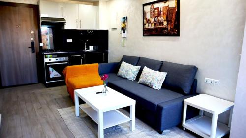 a living room with a blue couch and two tables at Beautiful and cosy apartment in Casablanca