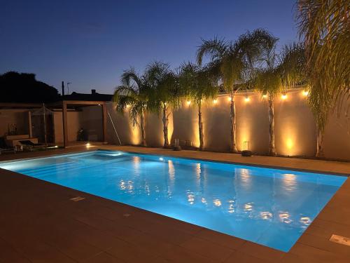 a swimming pool with lights on a fence at Signorino Suites&Pool in Marsala