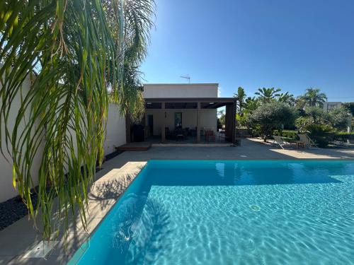 a swimming pool in front of a house at Signorino Suites&Pool in Marsala