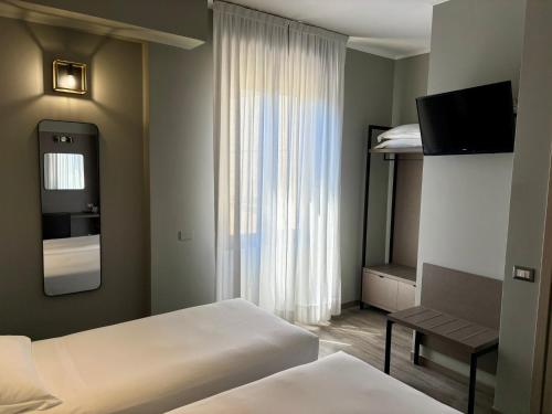 a hotel room with two beds and a television at Hotel Perugino in Milan