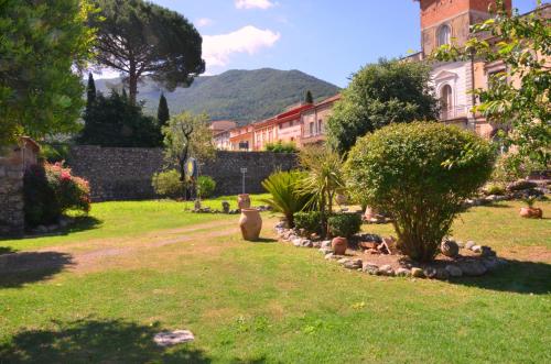a garden with a building and some bushes and trees at Hotel Del Sole Al Plebiscito in Sapri