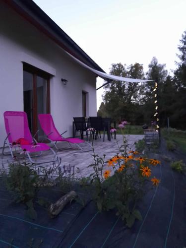 a patio with pink chairs and a table at Przystanek Bereżnica in Bereżnica Wyżna