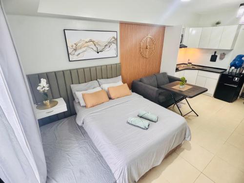une chambre avec un lit et un salon dans l'établissement Avida Towers Riala T3 Tunechi, à Cebu