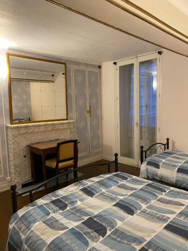 a bedroom with two beds and a desk and a mirror at Le Trèfle de l'Impériale-Les gites de l imperiale in Sermizelles