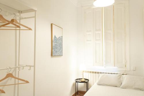 a white bedroom with a bed and a window at Magdalena 2 in Madrid