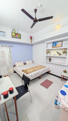 a bedroom with a bed and a ceiling fan at Krishnaalay Guest House in Ujjain